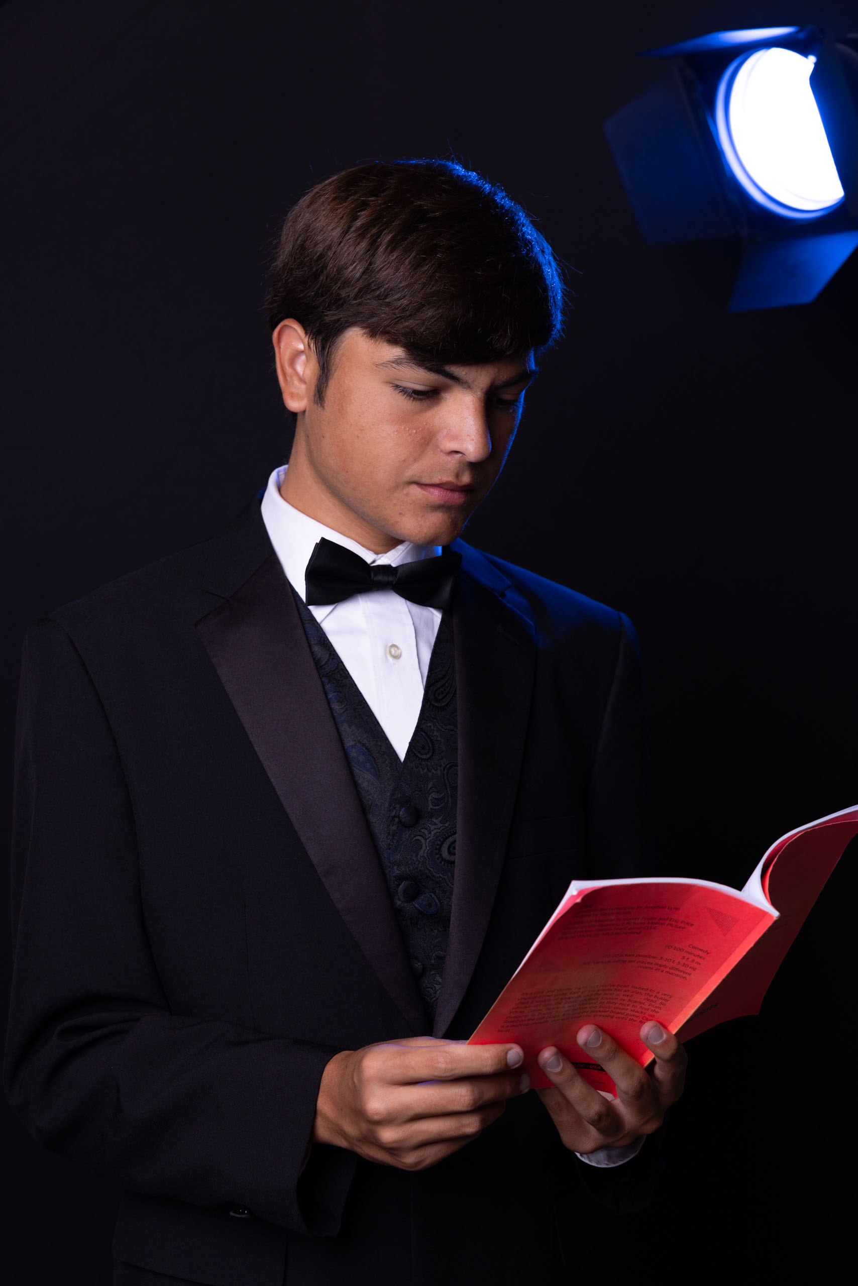 Teenage boy with script and theater lighting